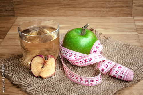 Apple juice with apples on wooden background