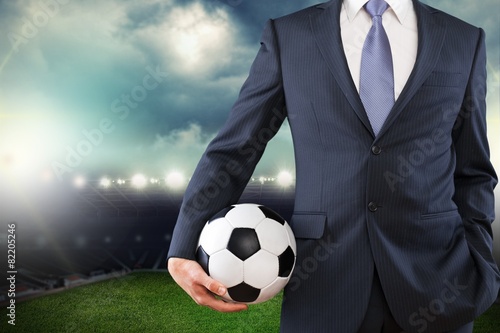 Soccer. Elegant businessman holding a soccer ball  close up