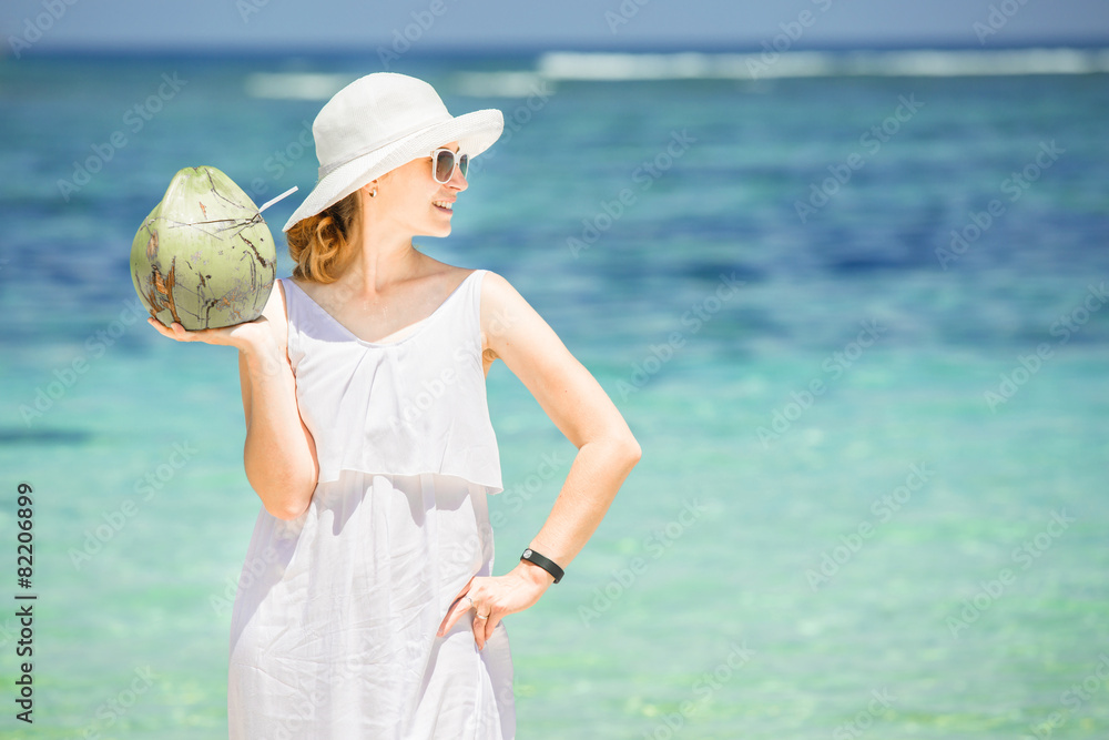 Beautiful young woman holding and drinkind a coconut fresh