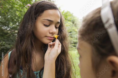 Mixed race girls smelling flowers photo