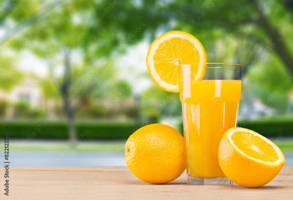 Naklejka premium Background. Fresh orange juice on wooden table over grunge