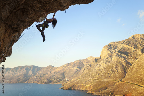 Female rock climber on overhanging cliff, Kalymnos Island, Greece