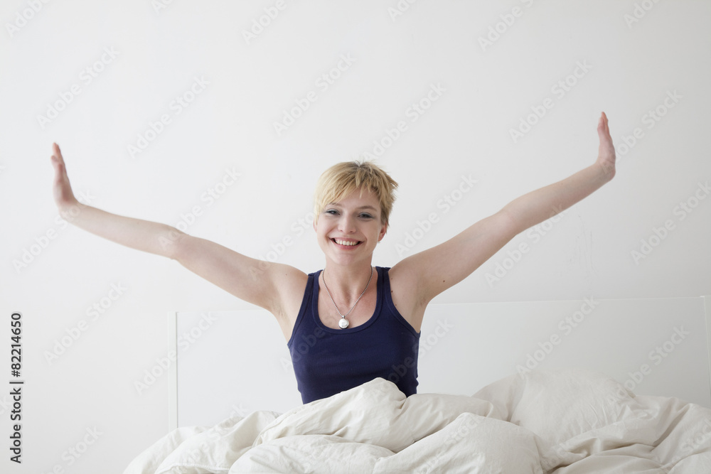Caucasian woman stretching on bed Caucasian woman stretching on bed