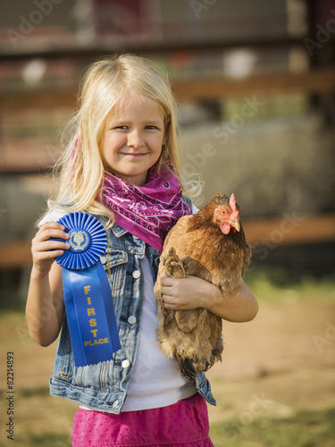 Caucasian girl with prize winning chicken on farm
