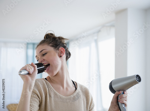 Hispanic girl singing into hairbrush