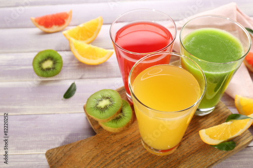 Fresh juices with fruits on wooden table
