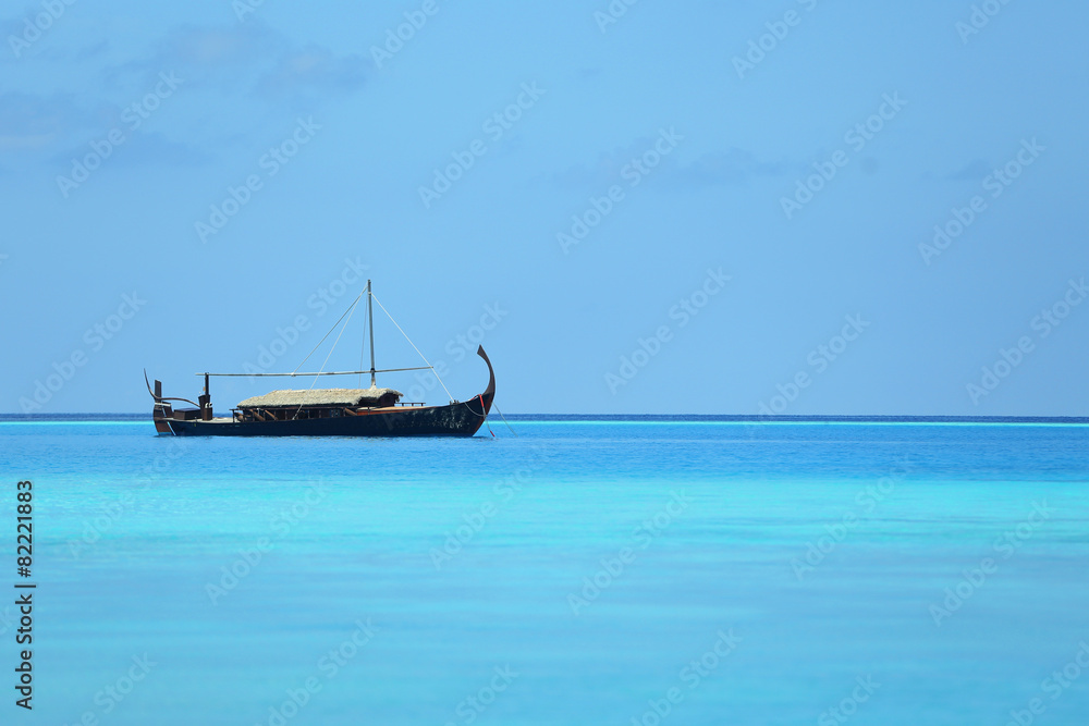 View of beautiful blue ocean water with boat in Baros Maldives