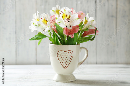 Fototapeta Naklejka Na Ścianę i Meble -  Beautiful flowers in cup, on wooden background