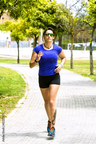 Woman running in the park with sunglasses