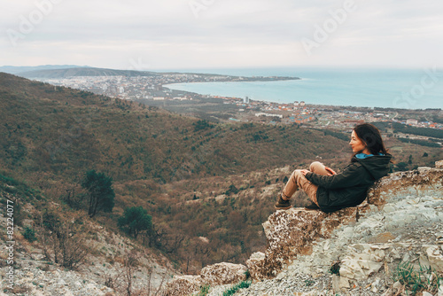 Woman resting in the mountains over the town