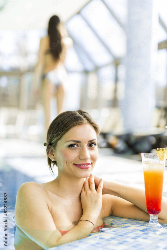 Beautiful woman in a pool with a cocktail Beautiful woman in a pool with a cocktail