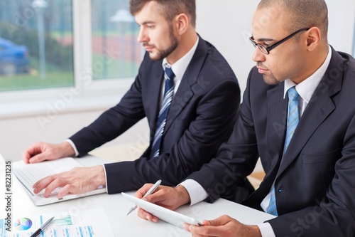 Wallpaper Mural Review. Image of two young businessmen using touchpad Torontodigital.ca