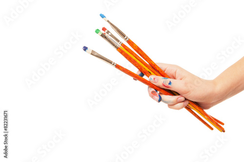 Hand holding brushes isolated on white