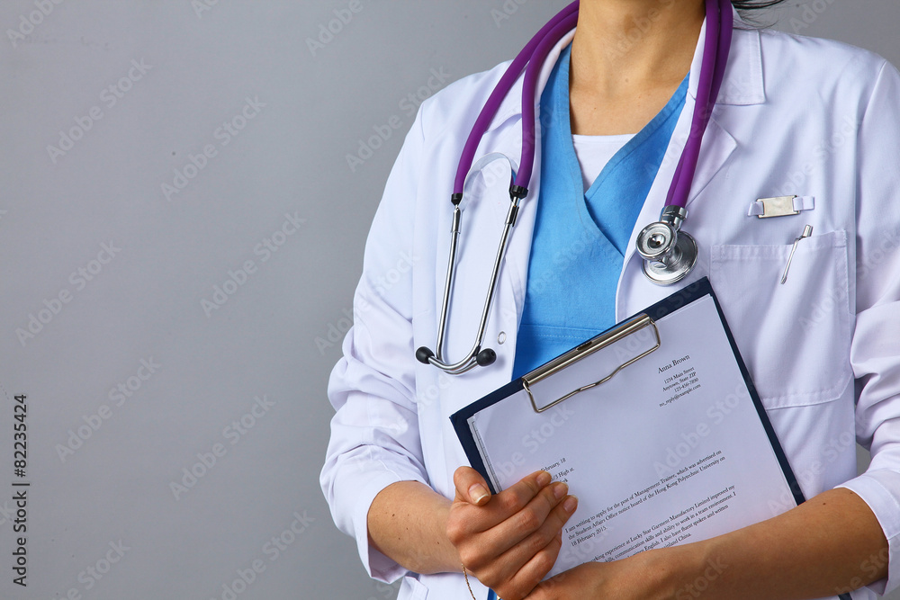 Female doctor standing with a folder , isolated on white Female doctor standing with a folder , isolated on white