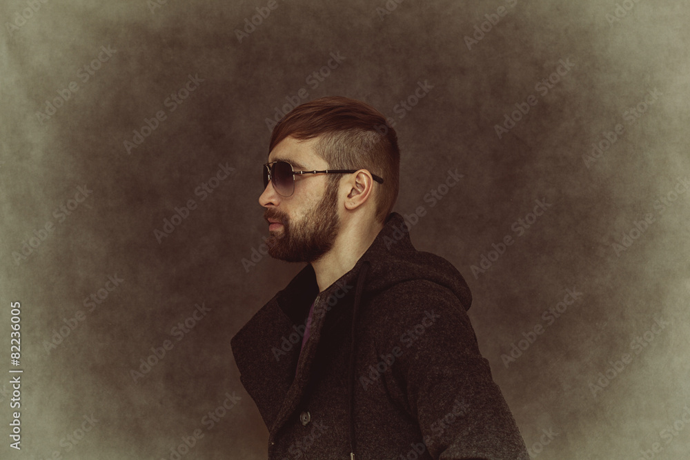 Fototapeta premium Brutal man-hipster with fashionable hairstyle and beard
