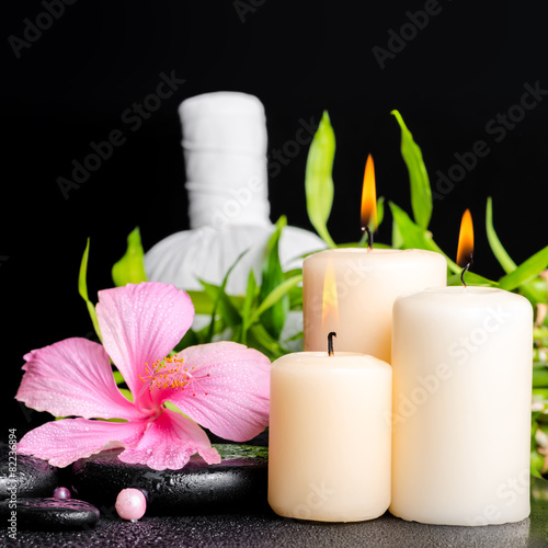 spa setting of hibiscus flower, twig bamboo, thai herbal compres