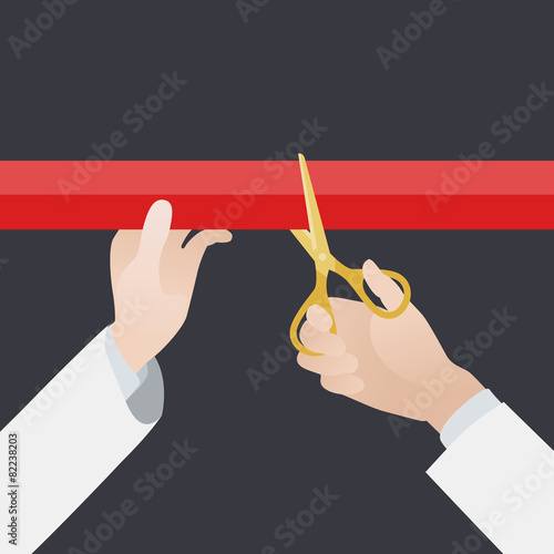 Hand with golden scissors cut the red ribbon