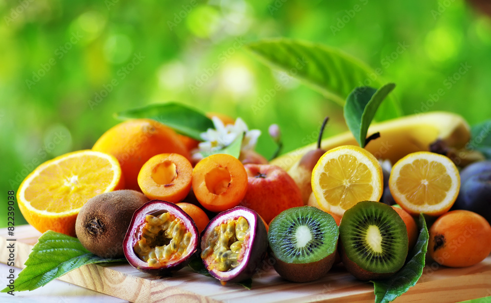 Fruits with leafs on table on green background Fruits with leafs on table on green background
