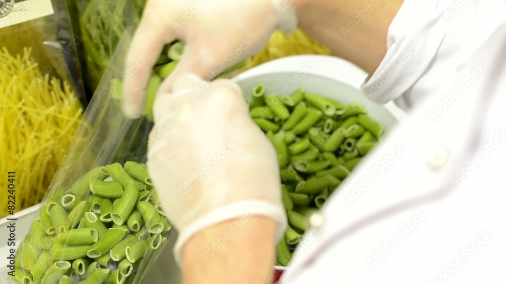 chef puts dried pasta into bags - factory - closeup chef puts dried pasta into bags - factory - closeup