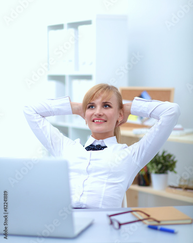 Business woman relaxing with  hands behind her head and sitting