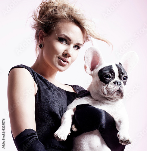Elegant blonde woman posing with pug dog.