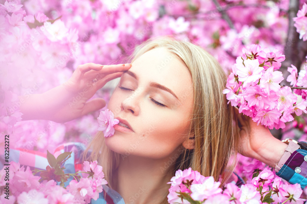 Fresh spring photo of beauty young blonde with flower in mouth