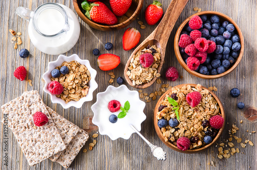 Fresh healthy breakfast with granola and berries, wooden backgro
