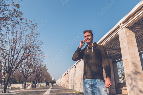 Young handsome man talking on phone