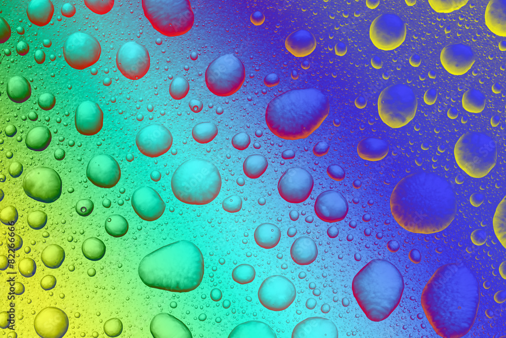 Abstract background, colored water drops on transparent surface