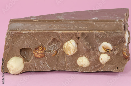 Milk chocolate with huzelnuts isolated on pink photo