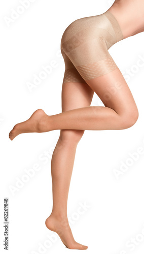 Фотография Beautiful girl in beige tights. Isolated on white background