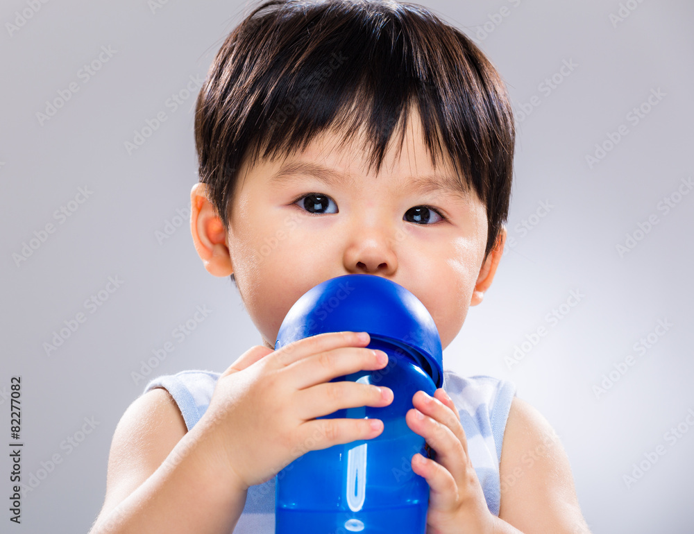 Baby boy drinking water using plastic bottle Baby boy drinking water using plastic bottle