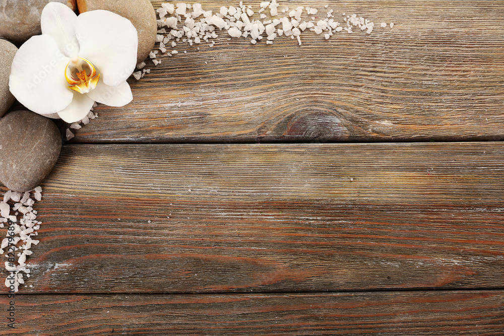 Spa stones and orchid flower on wooden background Spa stones and orchid flower on wooden background