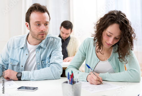 Slika na platnu Young attractive man trying to cheat during exams