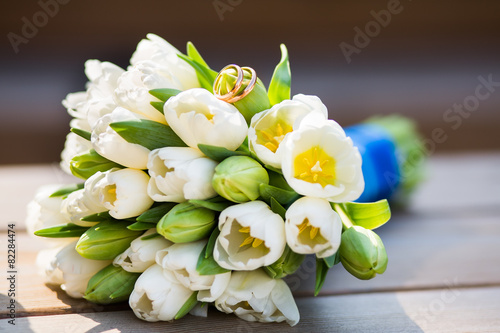 Wedding rings and bouquet of white tulips