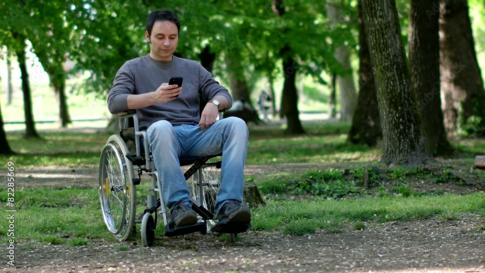 Portrait of a disabled man using his smartphone in a park Portrait of a disabled man using his smartphone in a park