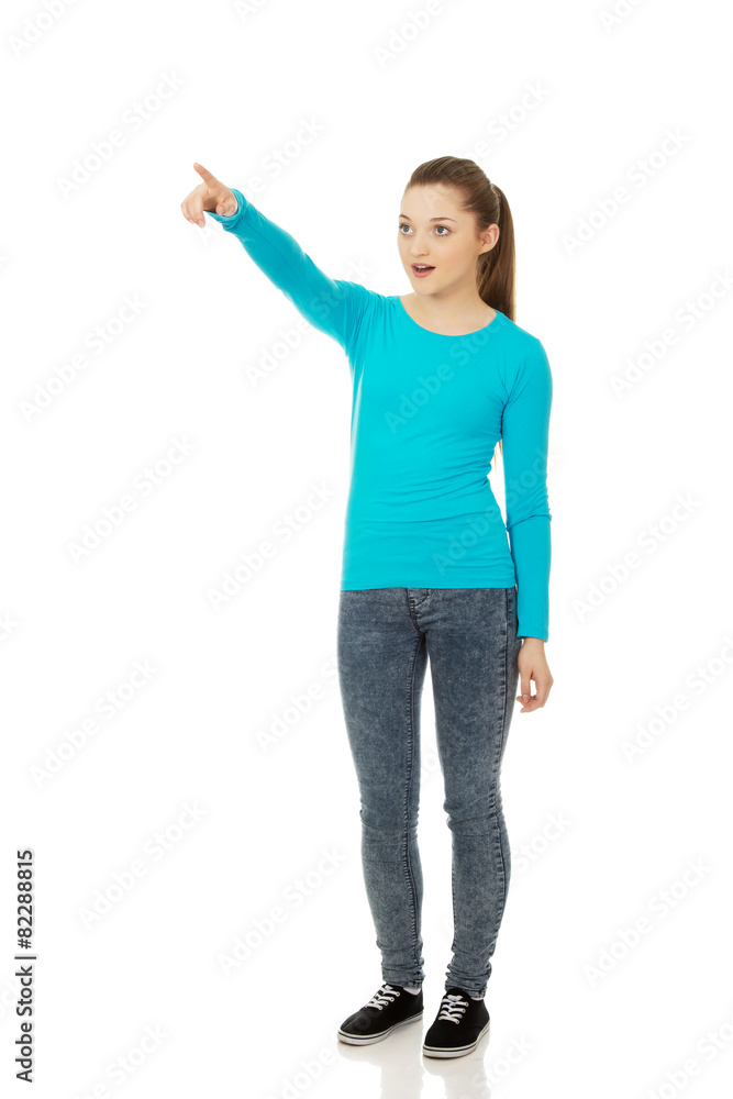 Shocked young woman pointing up. Shocked young woman pointing up.