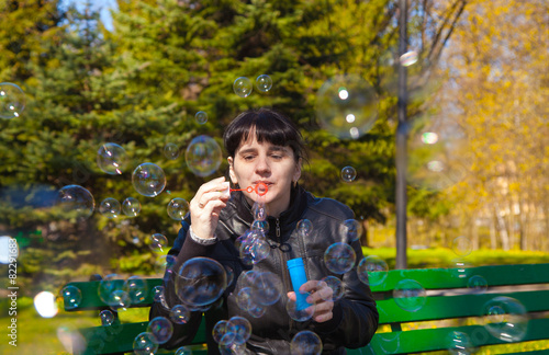 young beautiful brunette woman blowing bubbles