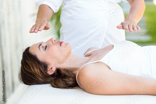 Calm woman receiving reiki treatment