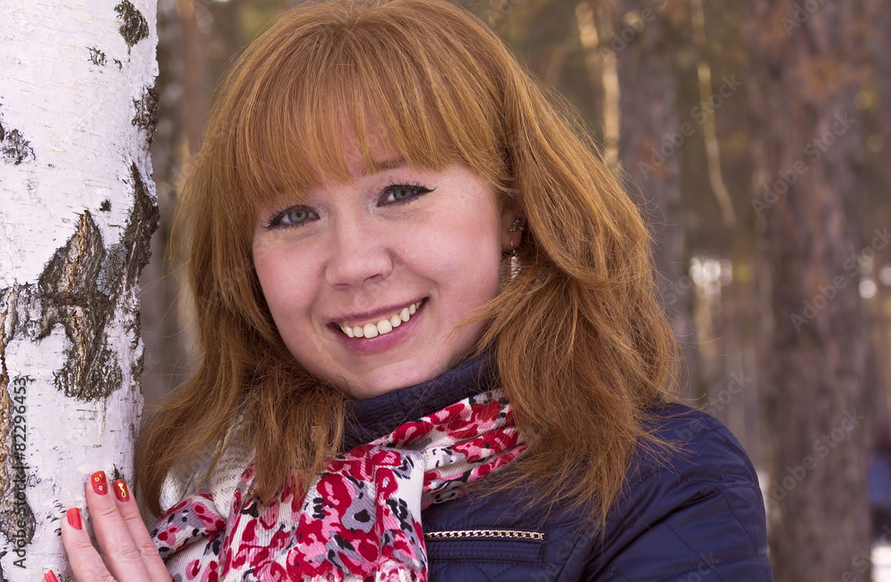 Of a cheerful red-haired girl in the Park among birches. Of a cheerful red-haired girl in the Park among birches.