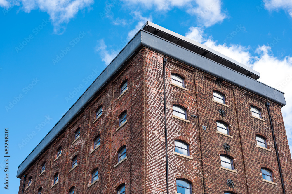 Brick building or factory with small windows and blue sky