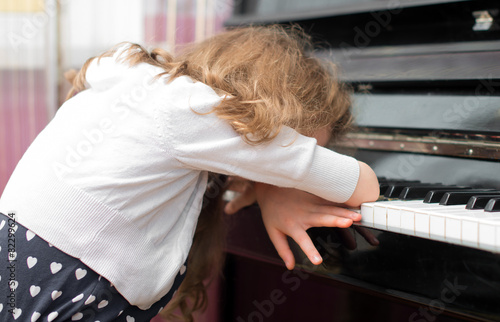 Child tired of learning the piano. photo