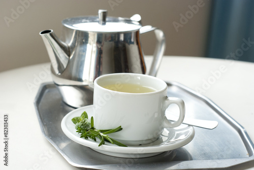 teapot and a cup with green herbal tea