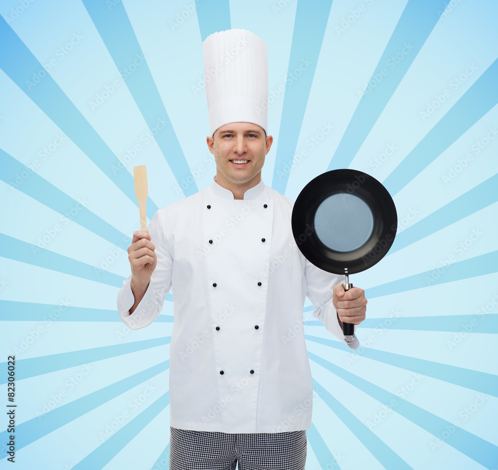 happy male chef holding frying pan and spatula happy male chef holding frying pan and spatula