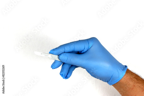 Hand with blue surgical glove and scalpel