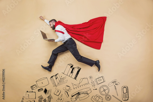 Manager in a cloak of superman. Studio shot on beige background