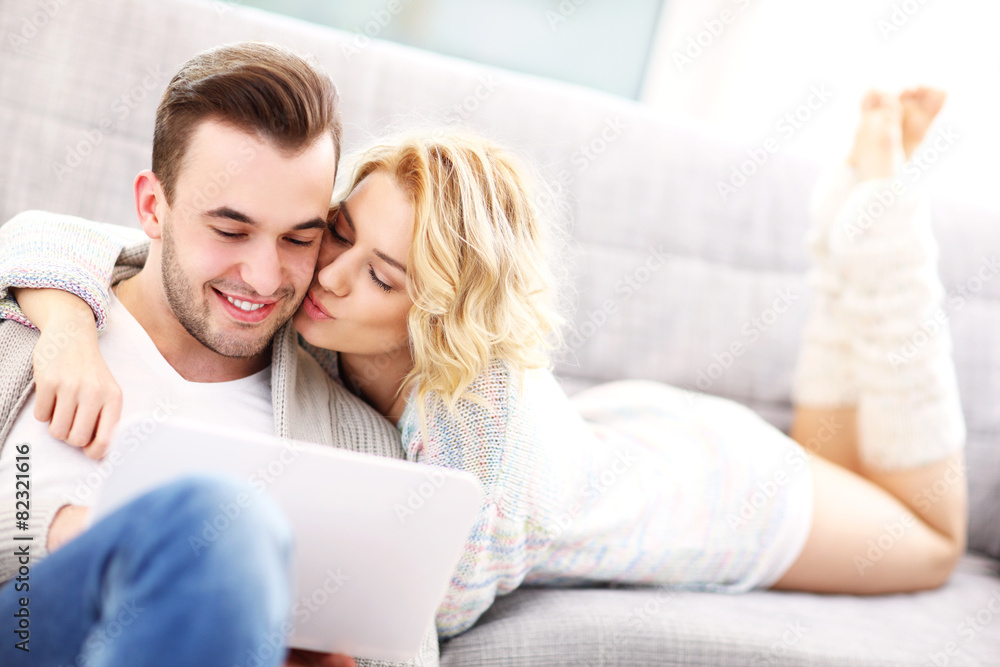 Romantic couple with laptop in living room Romantic couple with laptop in living room