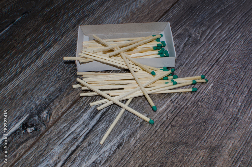 matches in the box and scattered on the wooden background matches in the box and scattered on the wooden background
