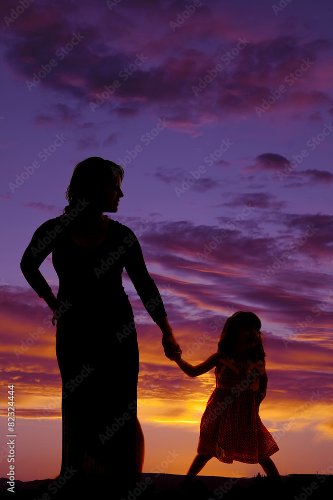 silhouette of mother and daughter hold hands