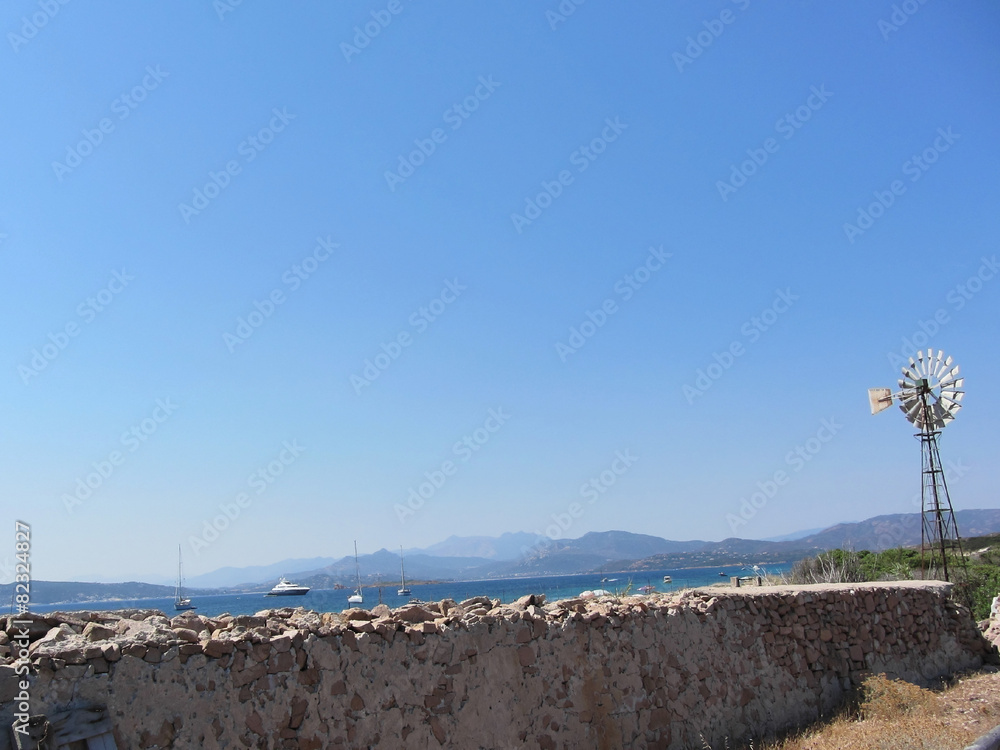 Ancient wall and windmill with seascape